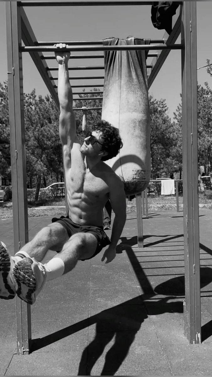 Athlete performing hanging leg raises on a pull-up frame