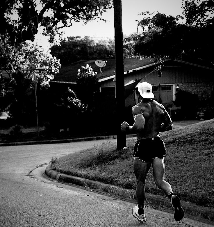 Runner training on an empty road at dusk